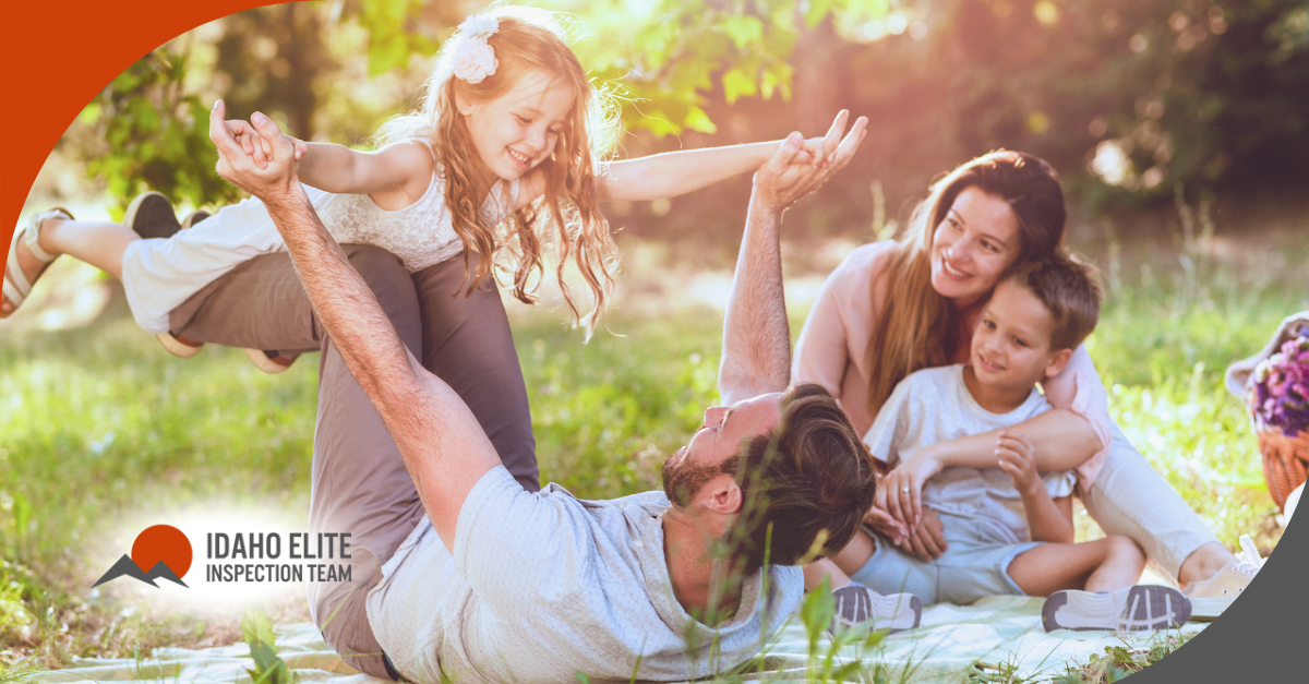 Family having fun outdoors, playing and laughing together on a picnic blanket
